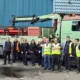 Staff of John Cameron Plumbers Builders Merchants Glasgow standing in front of a green truck
