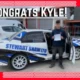 Congrats Kyle photo of Kyle next to a Shaw Stewart car